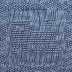 May include: A close-up of a blue knitted fabric with a woven pattern. The fabric has a textured surface and a subtle geometric design.