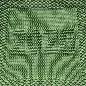May include: A close-up of a knitted green square with the word "Etsy" knitted into the centre. The word is in a sans-serif font. The border of the square has a textured pattern. The yarn is a solid green colour.