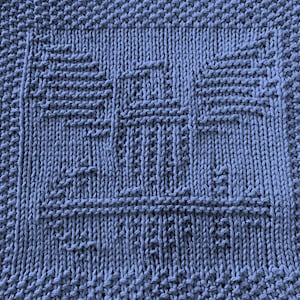 Op de afbeelding: Een blauwe gebreide theedoek met een textuurpatroon. De doek is gemaakt van katoen en is perfect voor het schoonmaken van de vaat of het drogen van handen.