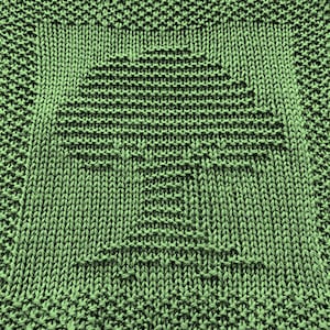 Peut inclure: Un torchon en tricot vert avec un motif carré au centre.