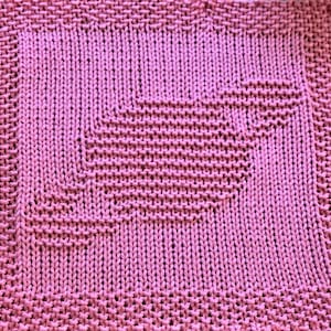 May include: A pink knitted dishcloth with a geometric pattern.