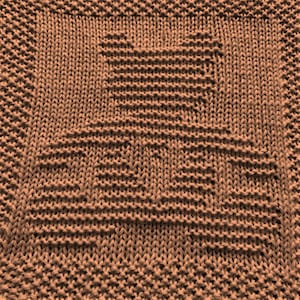May include: A brown knitted dishcloth with a square pattern.