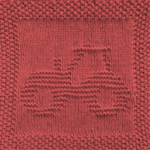 May include: A red knitted dishcloth with a woven design of a stylised heart.