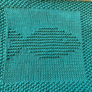May include: A teal blue knitted dishcloth with a woven pattern.