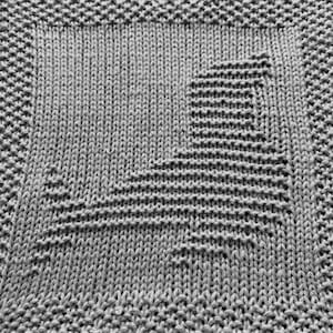 Puede incluir: Un paño de cocina de punto gris con un patrón geométrico en el centro.