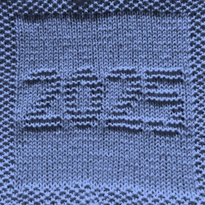 Op de afbeelding: Een blauwe gebreide theedoek met het woord "BEZE" geweven in de stof.