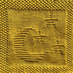 Puede incluir: Un paño de cocina de punto amarillo con un patrón geométrico.