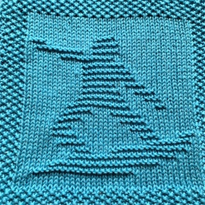 Könnte beinhalten: Ein türkisfarbener, gestrickter Geschirrtuch mit einem geometrischen Muster, das an einen stilisierten Baum erinnert.