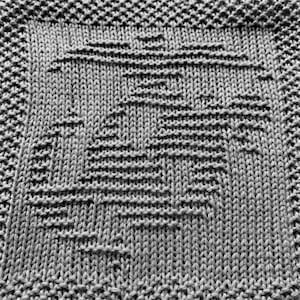 May include: A close-up of a gray knitted dishcloth with a geometric pattern.