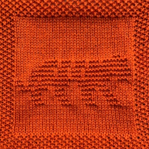 May include: A close-up of a knitted orange dishcloth with a woven pattern.