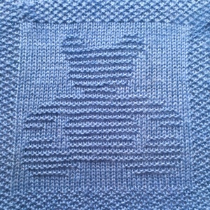 May include: A close-up of a blue knitted fabric with a geometric pattern. The fabric is made of a soft, textured yarn and has a subtle sheen.