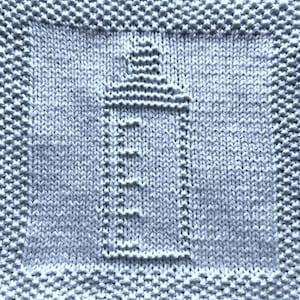 May include: A light blue knitted dishcloth with a baby bottle design.