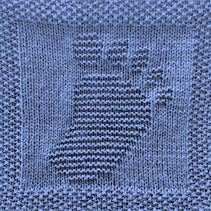 May include: A blue knitted dishcloth with a woven design. The dishcloth is made of cotton and is ideal for cleaning dishes and other surfaces.
