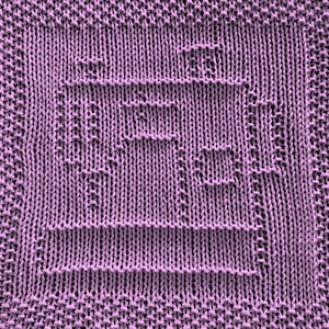 May include: A close-up of a knitted dishcloth in a light purple color. The dishcloth has a textured pattern that creates a design.