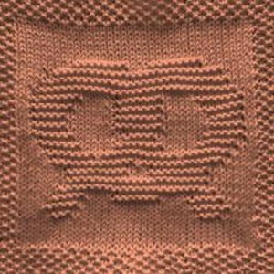 May include: A square-shaped, light brown knitted textile featuring a central pretzel-shaped design created with a raised knit pattern. The border consists of a textured seed stitch, while the background of the pretzel is smooth stockinette.