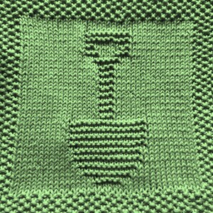 May include: A green knitted dishcloth with a simple, geometric design of a bottle or vase.