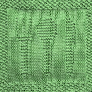 May include: A close-up of a knitted square in a light green colour. The square has a textured pattern with raised designs, possibly a blanket or decorative piece. The edges have a distinct border, adding to the overall design.