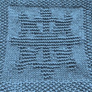 May include: A blue knitted dishcloth with a geometric pattern in the center.