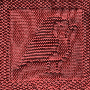 Könnte beinhalten: Ein quadratisches Stricktextil in einfarbigem Korallenrot. Die Mitte zeigt ein strukturiertes Strickmuster, das die Silhouette eines Vogels im Profil darstellt, umgeben von einem breiten Rand aus kraus rechts gestrickter Textur.