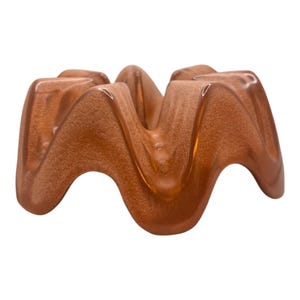 May include: A ceramic, wave-shaped decorative bowl in a speckled, copper-colored finish. The bowl has a glossy, smooth surface and a unique, organic design. The bowl is likely used for decorative purposes.