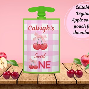 May include: Editable digital apple sauce pouch file download. Pink and white gingham pouch with a green lid. The pouch has a cherry design and the text "Caleigh's Sweet One".
