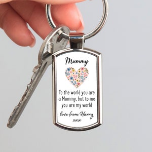 May include: Silver keyring with a rectangular tag that says "Mummy" with a floral heart design. The tag also includes the text "To the world you are a Mummy, but to me you are my world love from Harry xxx".
