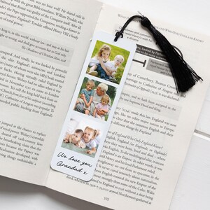 May include: A personalized bookmark featuring three family photos and a black tassel. The bookmark has the text "We love you Grandad x" in a handwritten style. The photos show a grandfather with his grandchildren.