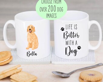 May include: Two white ceramic mugs featuring dog-themed designs. One mug displays a golden retriever illustration with the name Bella below it. The other mug features the text Life is Better with a Dog and two paw prints. A green oval overlay reads CHOOSE FROM OVER 200 DOG IMAGES.
