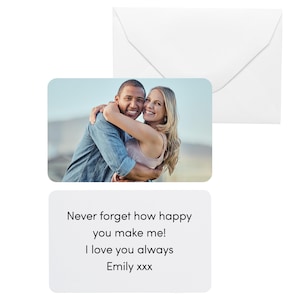 Pu&ograve; includere: Una busta bianca e un biglietto d'auguri con una fotografia di una coppia sorridente che si abbraccia. La carta ha il testo: "Non dimenticare mai quanto mi rendi felice! Ti amo sempre Emily xxx."