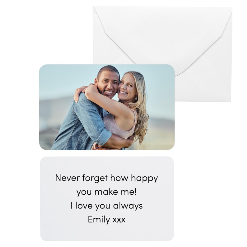Pu&ograve; includere: Una busta bianca e un biglietto d'auguri con una fotografia di una coppia sorridente che si abbraccia. La carta ha il testo: "Non dimenticare mai quanto mi rendi felice! Ti amo sempre Emily xxx."