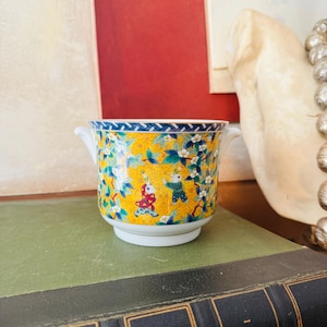 Puede incluir: Una taza de cerámica blanca con un asa negra y el texto "But First, Coffee" en negro y negrita. La taza está sobre una superficie blanca. La taza mide aproximadamente 10 cm de alto.