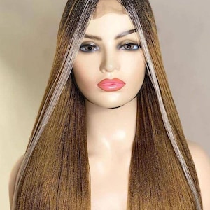 May include: A long, braided wig with a lace front. The wig features a blend of brown, blonde, and white strands, creating a highlighted effect. The braids are finely woven, and the wig is styled with a center part.