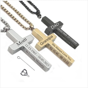 May include: Three silver, gold and black cross pendants with engraved names and dates. The silver cross says "Mom" with the dates "12-13-1965 - 10-05-2023" and "In Loving Memory". The gold cross says "Grandpa" with the dates "02-15-45 - 05-13-22" and "We Always Love You". The black cross says "Dad" with the dates "05-25-1945 - 07-10-2022" and "We Always Love You".