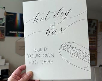 Letrero de perrito caliente con caligrafía hecha a mano, papel artesanal con bordes irregulares.