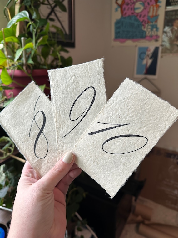 Hand torn deckled table numbers on handmade paper, script calligraphy table numbers on textured paper