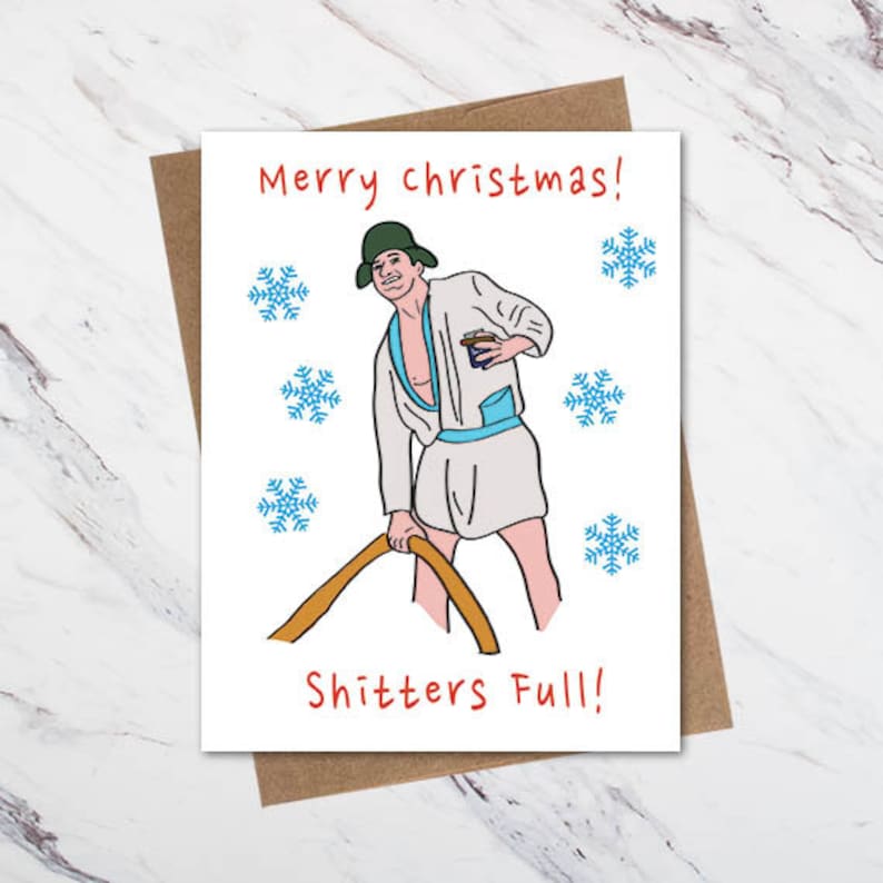 May include: A Christmas card featuring a cartoon illustration of a man in a white bathrobe holding a cup of coffee. The text on the card reads "Merry Christmas!" and "Shitters Full!" with snowflakes in the background.