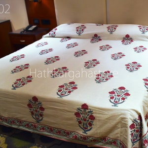 May include: A white bedspread with a red and blue floral pattern. The bedspread is on a bed with a wooden headboard. The text "DC02" and "Hathkaraghastore" are visible in the image.