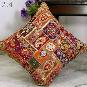 Puede incluir: Una funda de cojín de patchwork colorido con bordados intrincados y lentejuelas. La funda presenta una variedad de colores, incluyendo rojo, naranja, verde y dorado. La funda de cojín está hecha de una tela suave y duradera y es perfecta para agregar un toque de estilo bohemio a cualquier habitación.