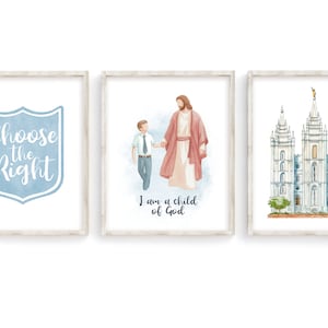 May include: Three framed prints with watercolor illustrations. The first print features a blue shield with the text "Choose the Right". The second print shows a man in a red robe holding the hand of a boy in a blue suit. The text below reads "I am a child of God". The third print shows a white building with multiple spires.