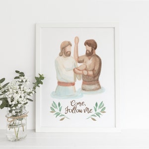 Peut inclure: Une peinture à l'aquarelle de Jésus baptisant un homme dans une rivière. La peinture est encadrée dans un cadre blanc et porte le texte "Venez, suivez-moi" écrit sous l'image.