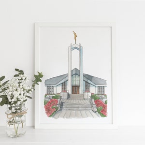 Puede incluir: Una pintura de acuarela de una iglesia blanca con una torre alta y una estatua en la cima. La iglesia tiene un techo gris y una gran puerta de madera. Hay flores rojas y arbustos verdes frente a la iglesia.