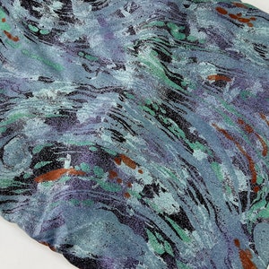 May include: A blue fabric with a swirling, abstract pattern in shades of green, purple, and brown.