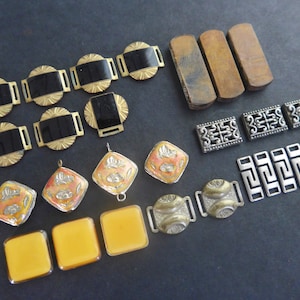 Może przedstawiać: Zestaw vintage metalowych i plastikowych klamer do pasów w różnych kształtach, rozmiarach i kolorach. Klamry są złote, srebrne, czarne i pomarańczowe. Niektóre klamry mają skomplikowane wzory.