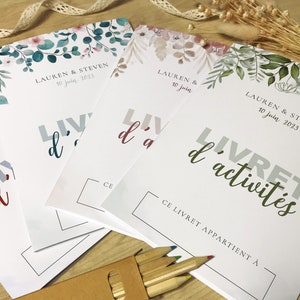 K&ouml;nnte beinhalten: Vier wei&szlig;e Aktivit&auml;tshefte mit floralen Illustrationen am oberen Rand, die den Text "LAUREN & STEVEN 10 juin 2023" und "LIVRET d'activit&eacute;s" sowie ein Feld f&uuml;r einen Namen unter "CE LIVRET APPARTIENT &Agrave;" enthalten.