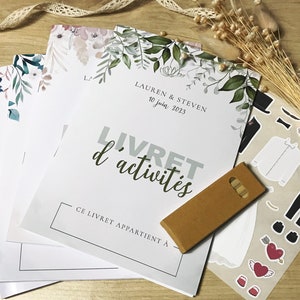 K&ouml;nnte beinhalten: Ein Stapel Aktivit&auml;tshefte mit Blumenillustrationen, mit dem Text LAUREN & STEVEN 10 juin 2023 LIVRET d'activit&eacute;s CE LIVRET APPARTIENT &Agrave;, dazu eine braune rechteckige Karte und ein Bogen mit Aufklebern von Kleidung und Herzen.