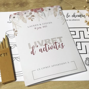 K&ouml;nnte beinhalten: Ein wei&szlig;es Aktivit&auml;tsheft mit dem Titel LIVRET d'activit&eacute;s, Blumenmotiven, den Namen Lauren & Steven und dem Datum 10 juin 2023. Es enth&auml;lt eine braune Pappschachtel mit Buntstiften und Bl&auml;tter mit schwarz-wei&szlig;en Strichzeichnungen.