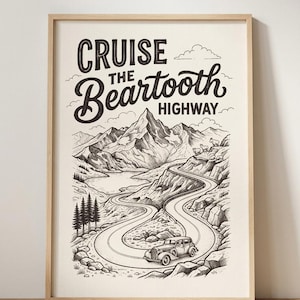 Puede incluir: Una lámina artística enmarcada en blanco y negro que muestra una carretera de montaña sinuosa con un coche antiguo, pinos y picos rocosos. El texto dice CRUISE THE Beartooth HIGHWAY. La ilustración incluye cabras montesas.