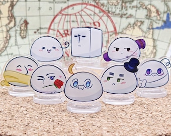 May include: A set of nine white and pastel-coloured cartoon character figurines. The characters are all round and have different facial expressions. They are standing on clear plastic bases.