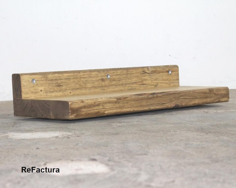 May include: A rustic wooden shelf with a natural finish. The shelf is made from reclaimed wood and has a unique, weathered look. It is perfect for adding a touch of rustic charm to any room.