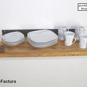 May include: A wooden shelf with a black metal bracket, holding white plates and mugs. The shelf is made of reclaimed wood and has a rustic look. The mugs have a purple and white design and the text "gesch&uuml;tztes Design" is visible in the upper right corner of the image.